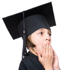Close up portrait of shocked little girl wearing black graduation hat - isolated on white background. Child back to school and educational concept.