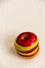 Mixed slices of red and green apple on white close