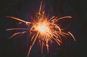 Bengal light with sparkles on dark background