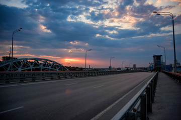 Fototapeta na wymiar View of modern concrete bridge over river at sunset