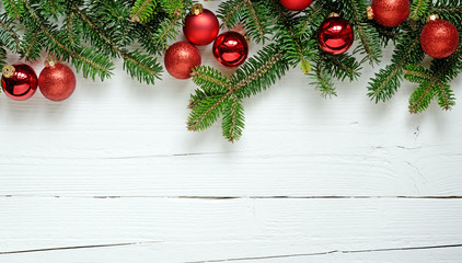 Fototapeta na wymiar cornice di Natale con rami di abete e palline rosse