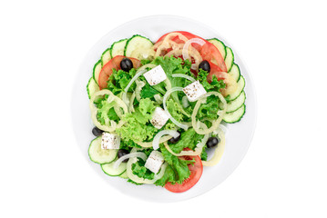Greek salad with feta cheese, olives, bell pepper, cucumber and tomato in a white plate isolated on white background. top view. flat lay