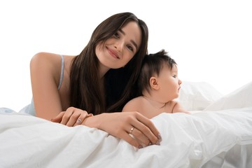 Young mother lying in bed with her little son