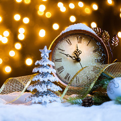 New Year's clock with decoration on snow