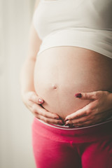 Pregnant woman with hands on her belly