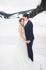 Beautiful gorgeous bride posing to groom and having fun near at mountains with amazing view, space for text, wedding couple