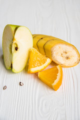 Sliced apple, orange and banana on white