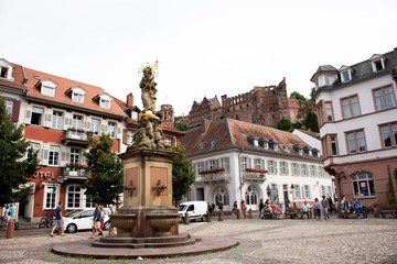 Fototapeta na wymiar German and foreigner travelers people walking and visit madonna statue at the corn market square in Heidelberg, Germany