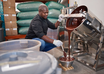 Worker melting chocolate while working in a confectionary factory