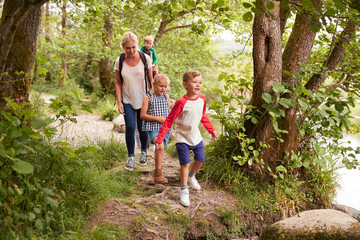 Naklejka na ściany i meble Family Hiking Along Path By River In UK Lake District