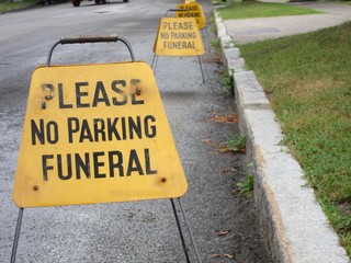 Line of No Parking signs for a funeral service