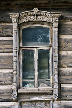 Old shabby carved window of a vintage russian wooden house