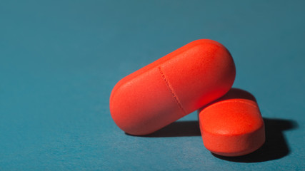 Two red capsules of medical pills isolated background