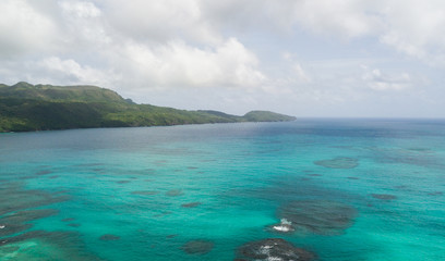 View of the ocean coast beach and mountains. Secluded white sand beach and mountains. Summertime Sea tranquility. Aerial view