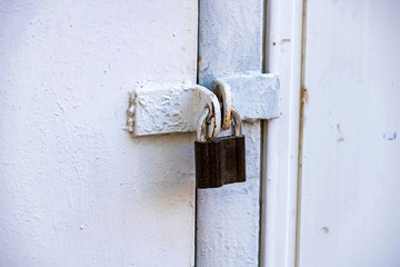 Old padlock on metal gate in black and white