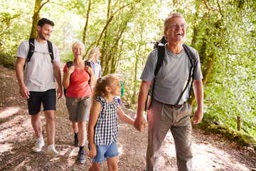 Multi Generation Family Enjoying Walk Along Woodland Path Together