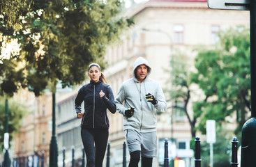 A fit couple running outdoors on the streets of Prague city.