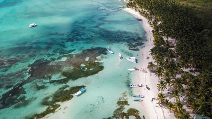 Boats on the sea. The boat is floating on the emerald clear sea between coral reefs. Aerial view