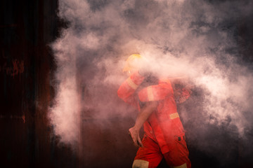 Firefighter with equipment try to help people trapped in house fire.