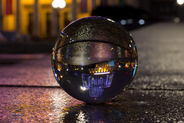 Palace of Culture and Science Warsaw - captured flipped reflection in crystal ball at night in rainy autumn time.