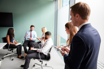 Group Having Discussion At Graduate Recruitment Assessment Day Whilst Being Observed By Recruitment...