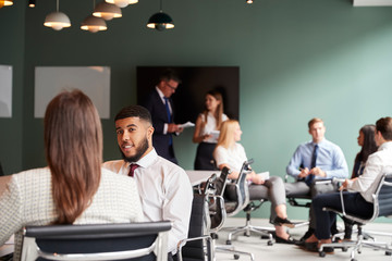 Businesswoman And Businessman Collaborating On Task Together At Graduate Recruitment Assessment Day