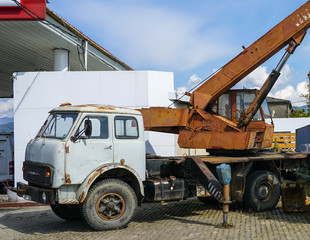 an old rusty soviet truck crane with an upright stroke