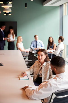 Businesswoman And Businessman Collaborating On Task Together At Graduate Recruitment Assessment Day