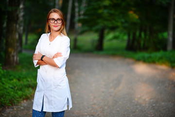 Nice attitude. a young girl who is a doctor stands outside, she