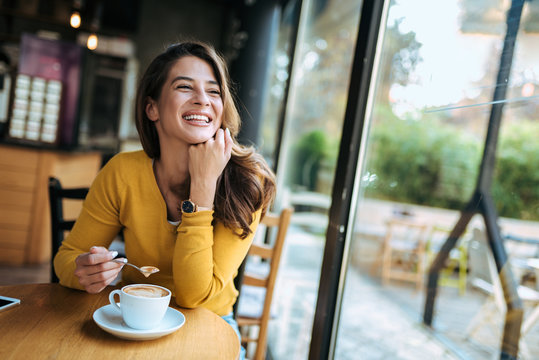 Happy Woman Drinking Coffee At The Cafe.