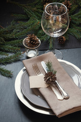 Christmas table setting with silverware and dark natural evergreen decor. Top view. Holiday Centerpieces.