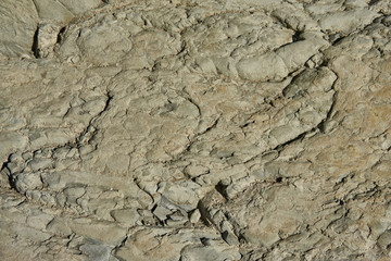 Mountain stone with a natural texture as a design concept. Cracks created by nature on the surface of the stone with a natural color scheme, create a natural textured background. Texture for design .