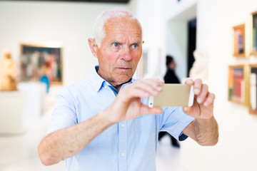 Man photographing painting in museum