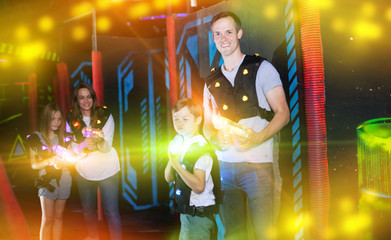 Father with son on lasertag arena in beams