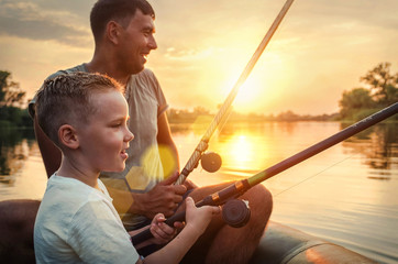 Happy Father and Son together fishing from a boat at sunset time - Powered by Adobe