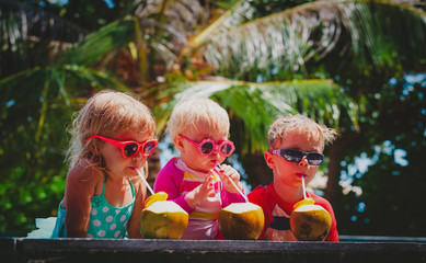 happy kids drinking coconut cocktail on beach resort