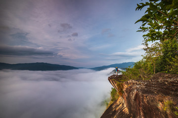 Young girl are taking photos  the sea of mist on high mountain in Nakornchoom, Phitsanulok province, Thailand.