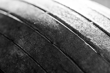 Old tread pattern for vehicle. Car wheel abrasion reduces safety. Close up black and white photo