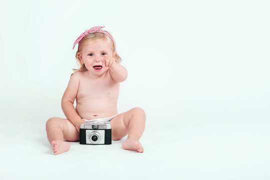 funny baby girl with retro camera on white background