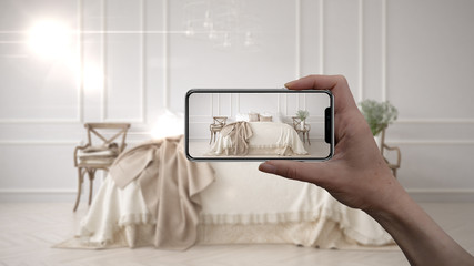 Hand holding smart phone, AR application, simulate furniture and interior design products in real home, architect designer concept, blur background, vintage classic bedroom