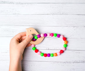 Children's hands holding a toy. Multi-colored beads. Wooden toy.