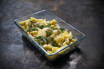 Ziemniaki pieczone, ziemniaki z rozmarynem i czosnkiem w naczyniu © foodandcook