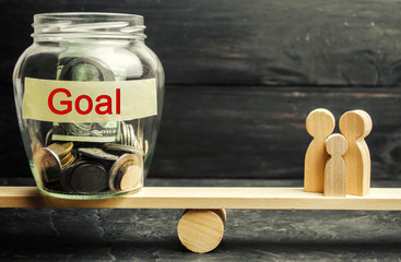 Family and glass jar with the inscription Goal. The concept of achieving family goals. The...