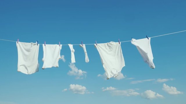 White linen dries on the rope against the blue sky