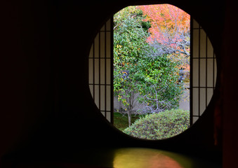 和室の丸窓から眺める紅葉