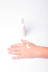 Children's hands and cream in a white tube. On white background. Baby skin care.