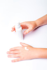 Children's hands and cream in a white tube. On white background. Baby skin care.