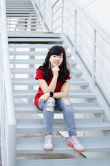 Attractive young asian woman wearing fashionable red clothes and jean posing on the iron stair.
A portrait of a beautiful asian woman smiling brightly at the camera.