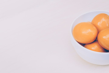 Fresh red eggs inside a white bowl.