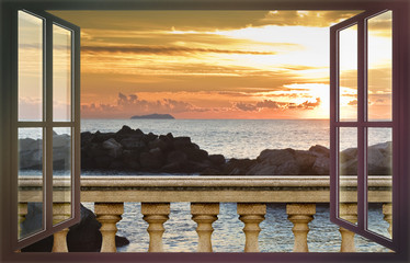 Concrete balustrade against a calm sea at sunset - concept image seen from a window